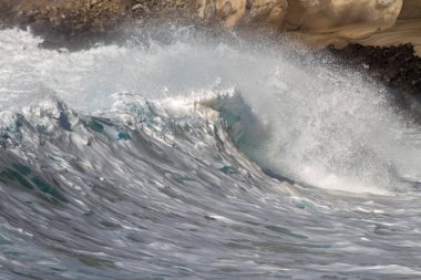 Bol köpüklü dalgalar, Atlantik Okyanusu 'nun volkanik siyah kumlu sahilinde, arka planda kayaları ve kayaları gören dalgalar. Los Gigantes, Tenerife, Kanarya Adaları 'ndan Cliff. İspanya