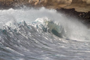 Bol köpüklü dalgalar, Atlantik Okyanusu 'nun volkanik siyah kumlu sahilinde, arka planda kayaları ve kayaları gören dalgalar. Los Gigantes, Tenerife, Kanarya Adaları 'ndan Cliff. İspanya