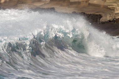 Bol köpüklü dalgalar, Atlantik Okyanusu 'nun volkanik siyah kumlu sahilinde, arka planda kayaları ve kayaları gören dalgalar. Los Gigantes, Tenerife, Kanarya Adaları 'ndan Cliff. İspanya