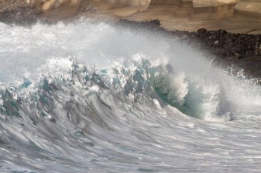 Bol köpüklü dalgalar, Atlantik Okyanusu 'nun volkanik siyah kumlu sahilinde, arka planda kayaları ve kayaları gören dalgalar. Los Gigantes, Tenerife, Kanarya Adaları 'ndan Cliff. İspanya
