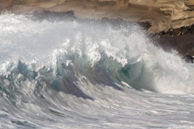 Bol köpüklü dalgalar, Atlantik Okyanusu 'nun volkanik siyah kumlu sahilinde, arka planda kayaları ve kayaları gören dalgalar. Los Gigantes, Tenerife, Kanarya Adaları 'ndan Cliff. İspanya