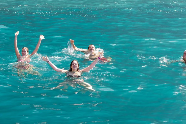 Bir grup insan, turistler, arka planda bir uçurumla Atlantik Okyanusu 'nun turkuaz sularında yüzüyorlar. Los Gigantes, Tenerife, Kanarya Adaları. İspanya