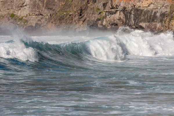 Bol köpüklü dalgalar, Atlantik Okyanusu 'nun volkanik siyah kumlu sahilinde, arka planda kayaları ve kayaları gören dalgalar. Los Gigantes, Tenerife, Kanarya Adaları 'ndan Cliff. İspanya