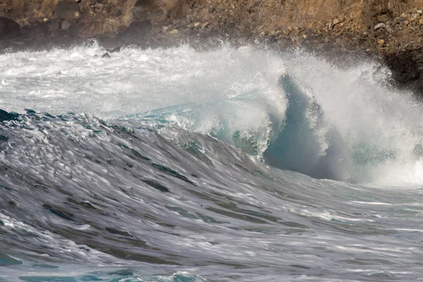 Bol köpüklü dalgalar, Atlantik Okyanusu 'nun volkanik siyah kumlu sahilinde, arka planda kayaları ve kayaları gören dalgalar. Los Gigantes, Tenerife, Kanarya Adaları 'ndan Cliff. İspanya
