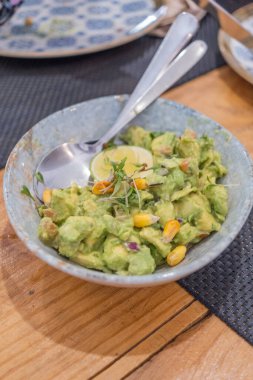 Haute mutfak tabağı, avokado ceviche ve farklı sebzeler, beyaz benekli, antika bir masada el yapımı gri bir seramik kasede servis ediliyor. Tenerife, Kanarya Adaları, İspanya