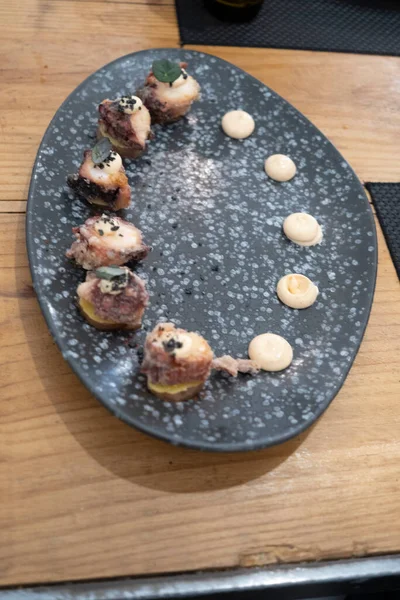 在一张老式桌子上的黑色火山岩盘上 有一小片油炸章鱼的高级美食盘的细节 Tenerife 加那利群岛 西班牙 — 图库照片