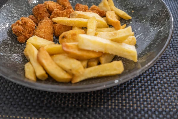 Beyaz el yapımı noktalarla süslenmiş siyah bir porselen tabakta servis edilen patatesli tavuk köftesi haute yemek tabağının ayrıntıları. Tenerife, Kanarya Adaları, İspanya