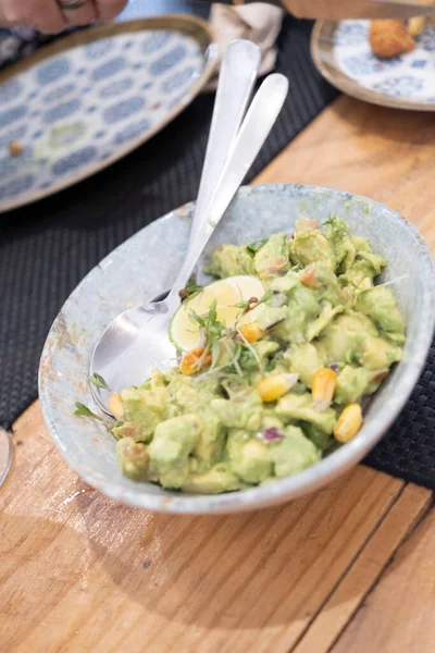 Haute mutfak tabağı, avokado ceviche ve farklı sebzeler, beyaz benekli, antika bir masada el yapımı gri bir seramik kasede servis ediliyor. Tenerife, Kanarya Adaları, İspanya