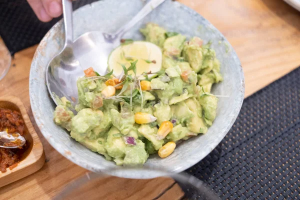 Haute mutfak tabağı, avokado ceviche ve farklı sebzeler, beyaz benekli, antika bir masada el yapımı gri bir seramik kasede servis ediliyor. Tenerife, Kanarya Adaları, İspanya