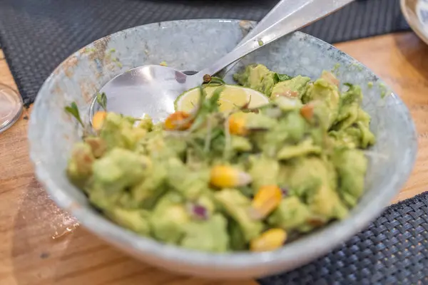 Haute mutfak tabağı, avokado ceviche ve farklı sebzeler, beyaz benekli, antika bir masada el yapımı gri bir seramik kasede servis ediliyor. Tenerife, Kanarya Adaları, İspanya
