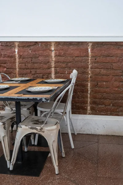 Kırmızı tuğla duvarları ve beyaz duvarları olan büyüleyici bir restoranın eski masaları ve sandalyeleri. Tenerife, Kanarya Adaları, İspanya