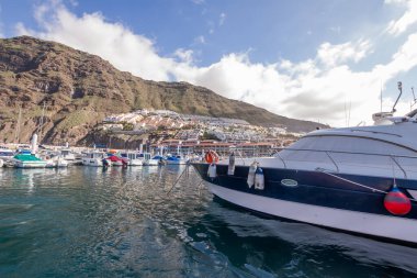 Yatı Los Gigantes rıhtımında demirlemiş ve arka planda Los Gigantes kasabası var. Tenerife, Kanarya Adaları. İspanya