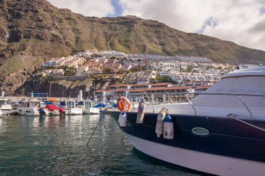 Yatı Los Gigantes rıhtımında demirlemiş ve arka planda Los Gigantes kasabası var. Tenerife, Kanarya Adaları. İspanya
