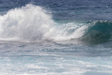 Kıyı şeridine doğru kopan bir dalganın yakın plan görüntüsü çok sayıda beyaz köpük oluşturur. Tenerife, Kanarya Adaları, İspanya