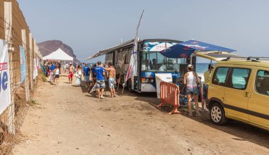 TENERİFE, SPAIN 11 - AGUSTAN 2013: Bir grup insan günü plajda şemsiyelerle, mayolarıyla, güneşlenerek, sahilde yüzerek ve kıyıdan badiba şampiyonasını izleyerek geçiriyorlar. Tenerife, Kanarya Adaları, Sp