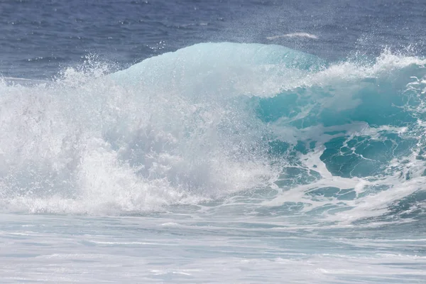 Kıyı şeridine doğru kopan bir dalganın yakın plan görüntüsü çok sayıda beyaz köpük oluşturur. Tenerife, Kanarya Adaları, İspanya