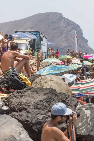 TENERİFE, SPAIN 11 - AGUSTAN 2013: Bir grup insan günü plajda şemsiyelerle, mayolarıyla, güneşlenerek, sahilde yüzerek ve kıyıdan badiba şampiyonasını izleyerek geçiriyorlar. Tenerife, Kanarya Adaları, Sp