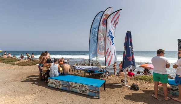 TENERİFE, SPAIN 11 - AGUSTAN 2013: Bir grup insan günü plajda şemsiyelerle, mayolarıyla, güneşlenerek, sahilde yüzerek ve kıyıdan badiba şampiyonasını izleyerek geçiriyorlar. Tenerife, Kanarya Adaları, Sp