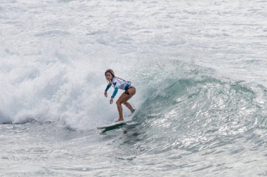 TENERIFE, SPAIN, NOVEMBER-03-2013: girl surfing in a surfing competition, performing several spectacular maneuvers on the wall of the wave. Tenerife, Canary Islands, Spain