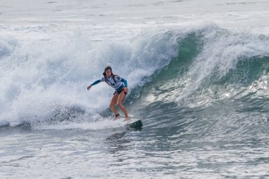 TENERIFE, SPAIN, NOVEMBER-03-2013: girl surfing in a surfing competition, performing several spectacular maneuvers on the wall of the wave. Tenerife, Canary Islands, Spain