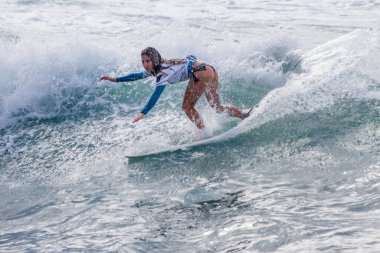 TENERIFE, SPAIN, NOVEMBER-03-2013: girl surfing in a surfing competition, performing several spectacular maneuvers on the wall of the wave. Tenerife, Canary Islands, Spain