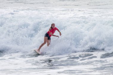 TENERIFE, SPAIN, NOVEMBER-03-2013: girl surfing in a surfing competition, performing several spectacular maneuvers on the wall of the wave. Tenerife, Canary Islands, Spain