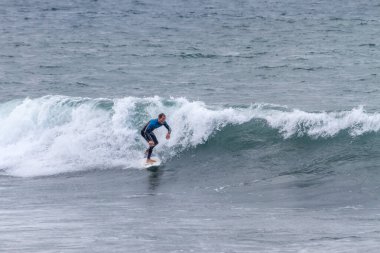 TENERIFE, SPAIN, 03-NOVEMBER-2013: Adam serbest sörf yapıyor ve dalganın duvarında radikal manevralar yapıyor. Tenerife, Kanarya Adaları, İspanya