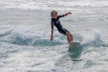 TENERIFE, SPAIN, NOVEMBER-03-2013: çocuk sörf yarışmasında sörf yapıyor, dalganın duvarında birkaç harika manevra yapıyor. Tenerife, Kanarya Adaları, İspanya