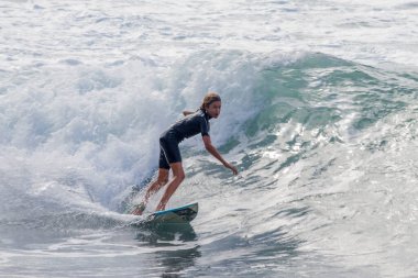 TENERIFE, SPAIN, NOVEMBER-03-2013: boy surfing in a children's surfing competition, performing several wonderful maneuvers on the wall of the wave. Tenerife, Canary Islands, Spain