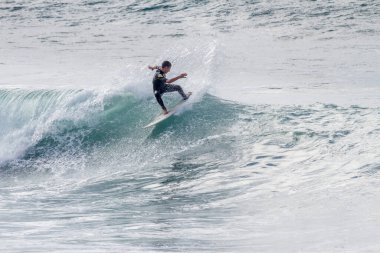 TENERIFE, SPAIN, NOVEMBER-03-2013: çocuk sörf yarışmasında sörf yapıyor, dalganın duvarında birkaç harika manevra yapıyor. Tenerife, Kanarya Adaları, İspanya