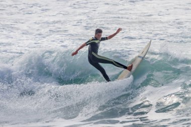 TENERIFE, SPAIN, NOVEMBER-03-2013: çocuk sörf yarışmasında sörf yapıyor, dalganın duvarında birkaç harika manevra yapıyor. Tenerife, Kanarya Adaları, İspanya