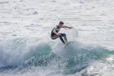 TENERIFE, SPAIN, NOVEMBER-03-2013: çocuk sörf yarışmasında sörf yapıyor, dalganın duvarında birkaç harika manevra yapıyor. Tenerife, Kanarya Adaları, İspanya