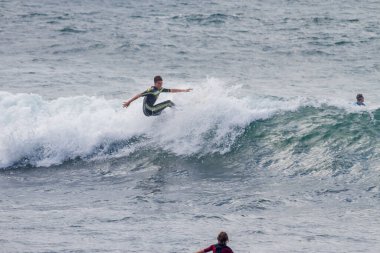 TENERIFE, SPAIN, NOVEMBER-03-2013: çocuk sörf yarışmasında sörf yapıyor, dalganın duvarında birkaç harika manevra yapıyor. Tenerife, Kanarya Adaları, İspanya