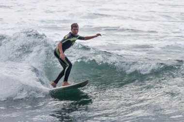 TENERIFE, SPAIN, NOVEMBER-03-2013: çocuk sörf yarışmasında sörf yapıyor, dalganın duvarında birkaç harika manevra yapıyor. Tenerife, Kanarya Adaları, İspanya