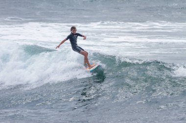 TENERIFE, SPAIN, NOVEMBER-03-2013: çocuk sörf yarışmasında sörf yapıyor, dalganın duvarında birkaç harika manevra yapıyor. Tenerife, Kanarya Adaları, İspanya