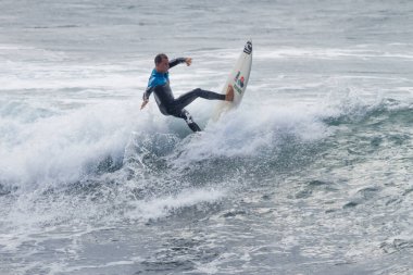 TENERIFE, SPAIN, NOVEMBER-03-2013: çocuk sörf yarışmasında sörf yapıyor, dalganın duvarında birkaç harika manevra yapıyor. Tenerife, Kanarya Adaları, İspanya