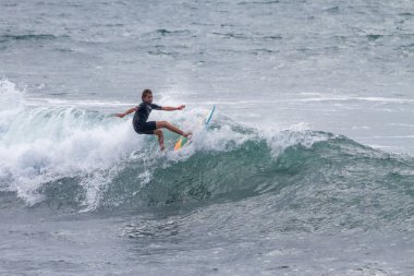 TENERIFE, SPAIN, NOVEMBER-03-2013: çocuk sörf yarışmasında sörf yapıyor, dalganın duvarında birkaç harika manevra yapıyor. Tenerife, Kanarya Adaları, İspanya