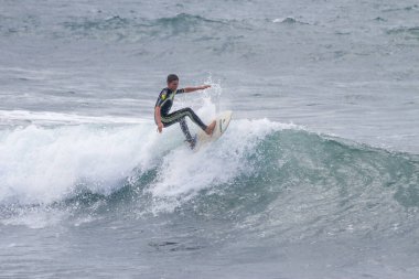 TENERIFE, SPAIN, NOVEMBER-03-2013: çocuk sörf yarışmasında sörf yapıyor, dalganın duvarında birkaç harika manevra yapıyor. Tenerife, Kanarya Adaları, İspanya