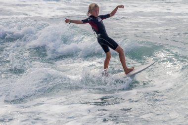 TENERIFE, SPAIN, NOVEMBER-03-2013: çocuk sörf yarışmasında sörf yapıyor, dalganın duvarında birkaç harika manevra yapıyor. Tenerife, Kanarya Adaları, İspanya
