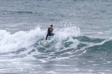 TENERIFE, SPAIN, NOVEMBER-03-2013: çocuk sörf yarışmasında sörf yapıyor, dalganın duvarında birkaç harika manevra yapıyor. Tenerife, Kanarya Adaları, İspanya