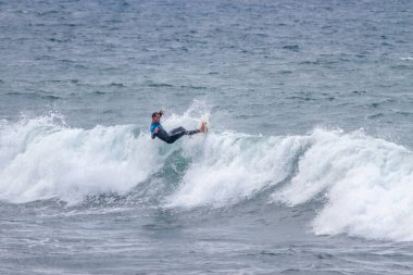TENERIFE, SPAIN, NOVEMBER-03-2013: çocuk sörf yarışmasında sörf yapıyor, dalganın duvarında birkaç harika manevra yapıyor. Tenerife, Kanarya Adaları, İspanya