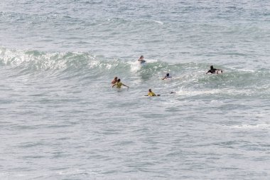 TENERIFE, SPAIN, NOVEMBER-03-2013: Sörf yarışmasında sörf yapmak ve yarışmak için dalgaların gelmesini bekleyen dört kız. Tenerife, Kanarya Adaları, İspanya