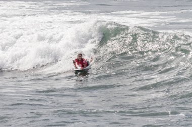 TENERIFE, SPAIN, NOVEMBER-03-2013: Sörfçü kız bir yarışmada, beyaz köpüklü sörf tahtası ile çeşitli manevralar yapar. Tenerife, Kanarya Adaları, İspanya