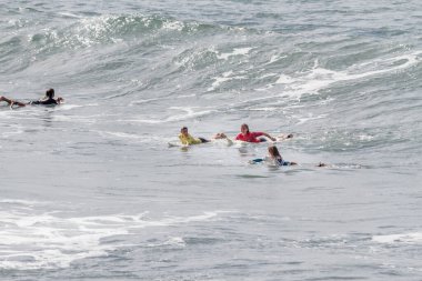 TENERIFE, SPAIN, NOVEMBER-03-2013: Sörf yarışmasında sörf yapmak ve yarışmak için dalgaların gelmesini bekleyen dört kız. Tenerife, Kanarya Adaları, İspanya