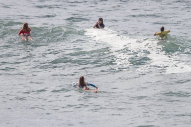 TENERIFE, SPAIN, NOVEMBER-03-2013: Sörf yarışmasında sörf yapmak ve yarışmak için dalgaların gelmesini bekleyen dört kız. Tenerife, Kanarya Adaları, İspanya