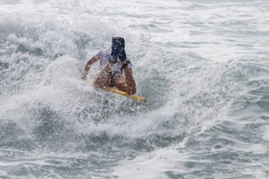 TENERIFE, SPAIN, NOVEMBER-03-2013: Sörfçü kız bir yarışmada, beyaz köpüklü sörf tahtası ile çeşitli manevralar yapar. Tenerife, Kanarya Adaları, İspanya
