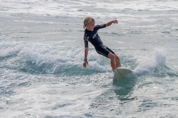 TENERIFE, SPAIN, NOVEMBER-03-2013: çocuk sörf yarışmasında sörf yapıyor, dalganın duvarında birkaç harika manevra yapıyor. Tenerife, Kanarya Adaları, İspanya