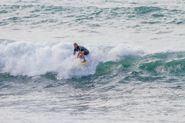 TENERIFE, SPAIN, NOVEMBER-03-2013: çocuk sörf yarışmasında sörf yapıyor, dalganın duvarında birkaç harika manevra yapıyor. Tenerife, Kanarya Adaları, İspanya