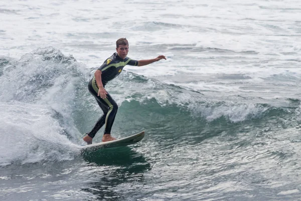 TENERIFE, SPAIN, NOVEMBER-03-2013: çocuk sörf yarışmasında sörf yapıyor, dalganın duvarında birkaç harika manevra yapıyor. Tenerife, Kanarya Adaları, İspanya