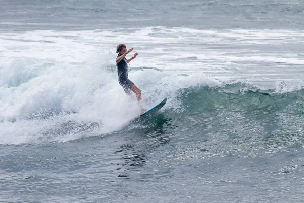 TENERIFE, SPAIN, NOVEMBER-03-2013: çocuk sörf yarışmasında sörf yapıyor, dalganın duvarında birkaç harika manevra yapıyor. Tenerife, Kanarya Adaları, İspanya